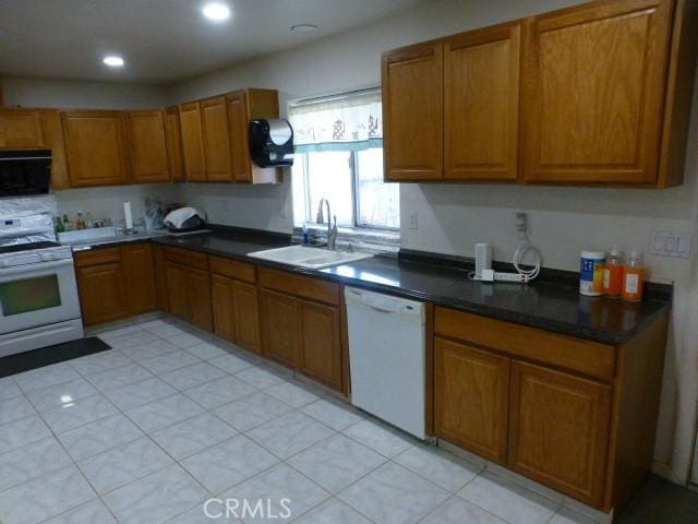 3465 Condor Rd Unit 29, Palms, CA 92277 - kitchen featuring dark countertops, a sink, brown cabinetry, white appliances, and recessed lighting