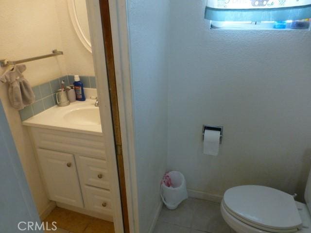 3465 Condor Rd Unit 29, Palms, CA 92277 - half bath featuring tile patterned floors, tasteful backsplash, toilet, baseboards, and vanity