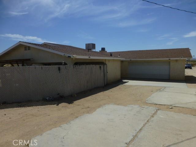 3465 Condor Rd Unit 29, Palms, CA 92277 - view of property exterior featuring an attached garage, driveway, stucco siding, and fence