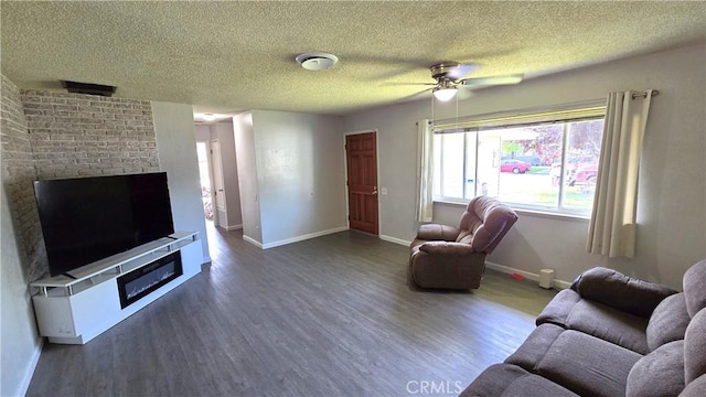 living area featuring wood finished floors, a textured ceiling, ceiling fan, a fireplace, and baseboards