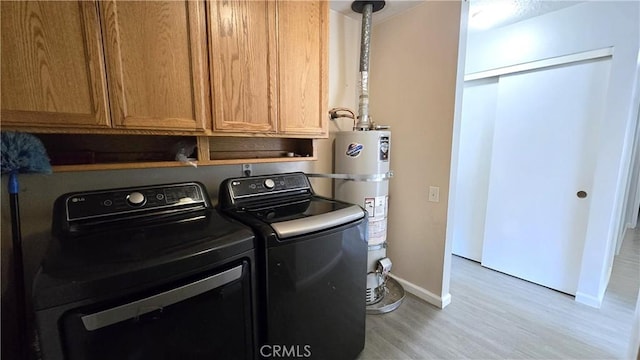 laundry area with light wood-style floors, secured water heater, baseboards, separate washer and dryer, and cabinet space