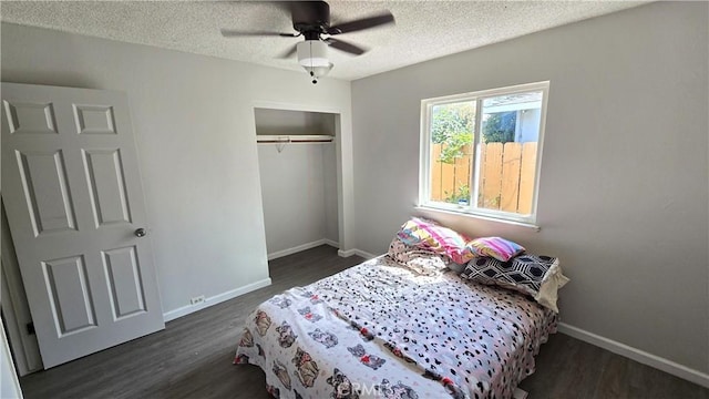 bedroom featuring dark wood-type flooring, a textured ceiling, a closet, and baseboards