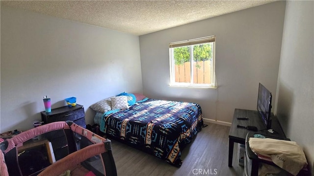 bedroom with wood finished floors and a textured ceiling