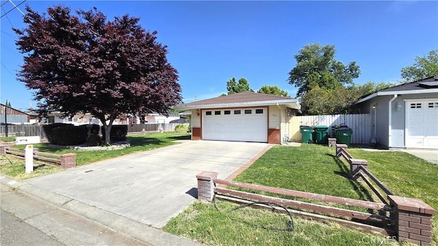 view of front of home featuring fence, brick siding, a front yard, and a detached garage