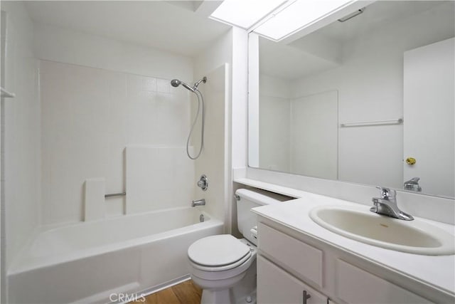bathroom featuring toilet, vanity, washtub / shower combination, and wood finished floors