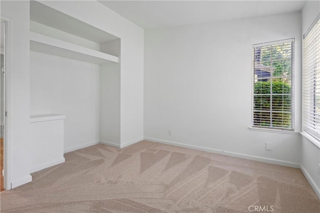 carpeted spare room with baseboards