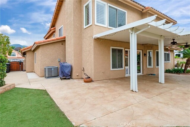 back of property with a patio, central AC unit, a gate, and stucco siding