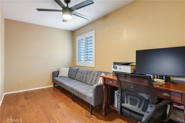 office area with a ceiling fan, baseboards, and wood finished floors