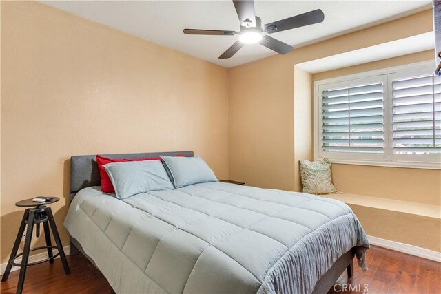 bedroom with baseboards, ceiling fan, and wood finished floors