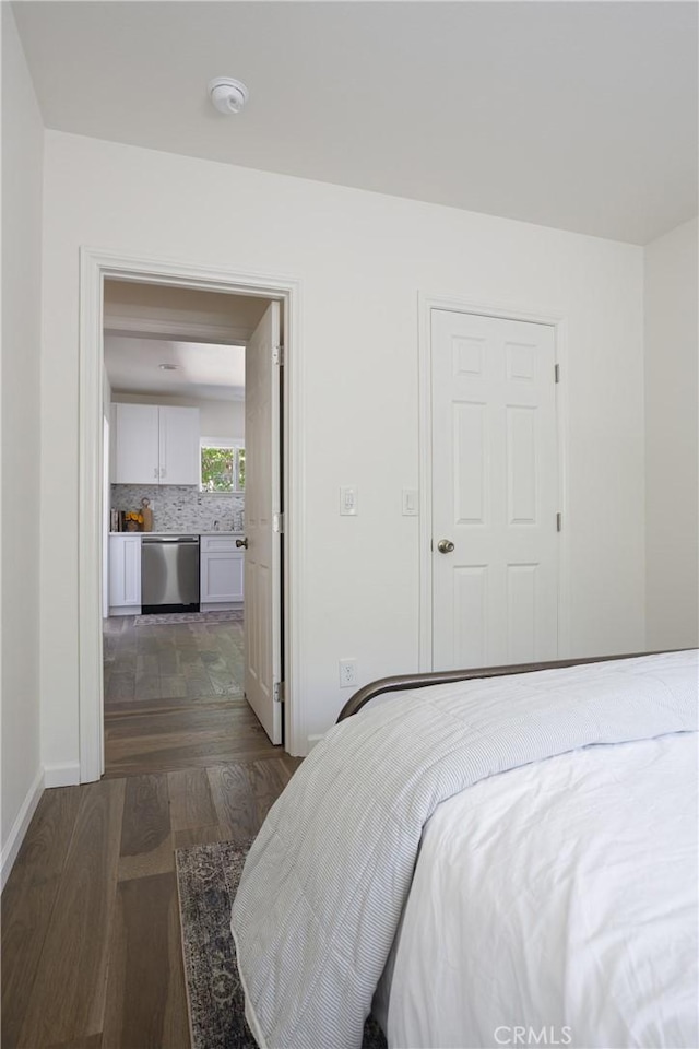 bedroom featuring baseboards and dark wood-style floors