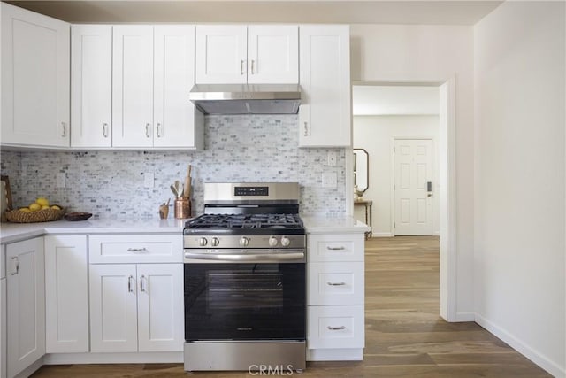 kitchen featuring light countertops, baseboards, wood finished floors, gas range, and under cabinet range hood