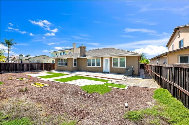 back of property with stucco siding, a patio area, central air condition unit, and a fenced backyard