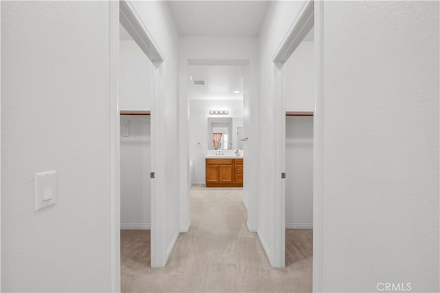 hall with light carpet and baseboards