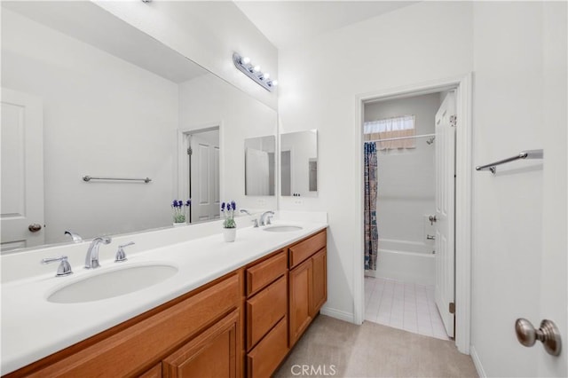 bathroom with double vanity, a sink, shower / tub combo with curtain, and baseboards
