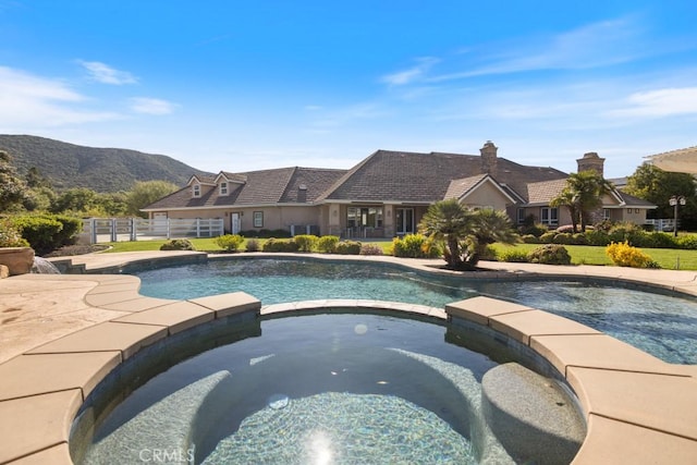 25032 Trilogy Trail Ln, Murrieta, CA 92562 - view of swimming pool featuring fence, a mountain view, and a pool with connected hot tub