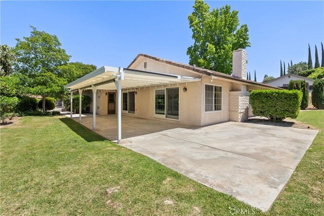 5655 Via Mensabe, Riverside, CA 92506 - rear view of house with a chimney, stucco siding, a lawn, and a patio area