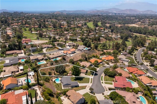 5655 Via Mensabe, Riverside, CA 92506 - aerial view of property and surrounding area with property parcel outlined, a pool area, a mountainous background, and nearby suburban area