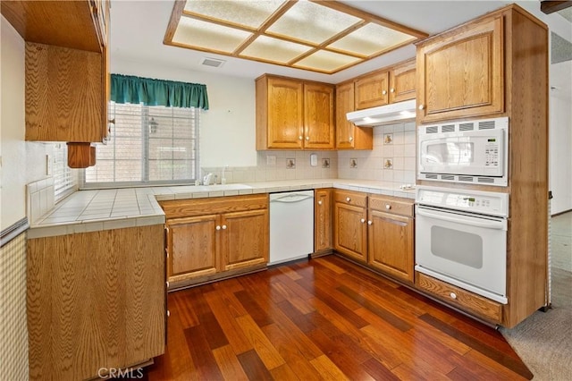 5655 Via Mensabe, Riverside, CA 92506 - kitchen featuring white appliances, under cabinet range hood, dark wood-type flooring, decorative backsplash, and tile counters