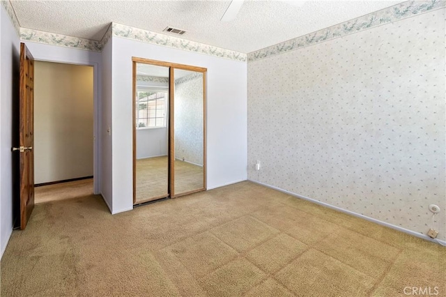5655 Via Mensabe, Riverside, CA 92506 - unfurnished bedroom with wallpapered walls, carpet floors, a textured ceiling, a closet, and ceiling fan