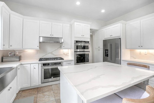 1693 Thompson Ave, Chula Vista, CA 91913 - kitchen with stainless steel appliances, under cabinet range hood, recessed lighting, white cabinets, and a center island