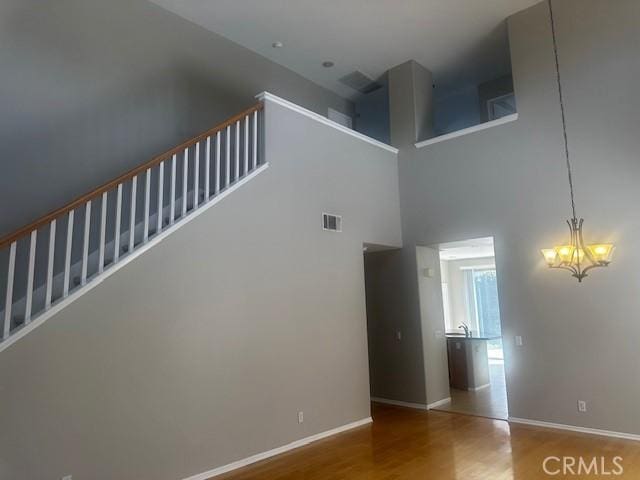 31329 Seminole St, Temecula, CA 92591 - staircase featuring wood finished floors, a chandelier, and a towering ceiling