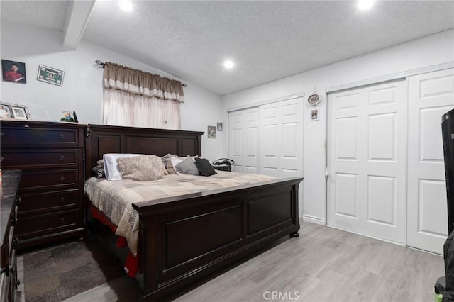 323 Whipple Mountain Rd, San Bernardino, CA 92410 - bedroom with recessed lighting, light wood-style flooring, multiple closets, and a textured ceiling