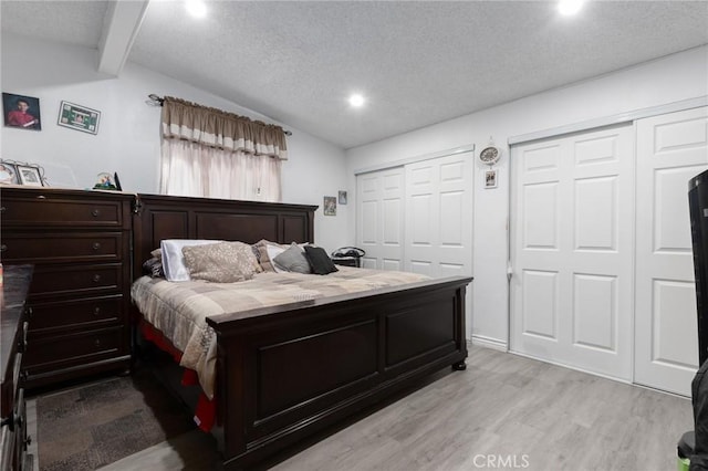 323 Whipple Mountain Rd, San Bernardino, CA 92410 - bedroom featuring two closets, light wood-style floors, recessed lighting, vaulted ceiling with beams, and a textured ceiling