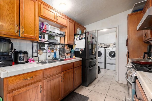 323 Whipple Mountain Rd, San Bernardino, CA 92410 - kitchen with independent washer and dryer, a sink, stainless steel appliances, tile countertops, and range hood