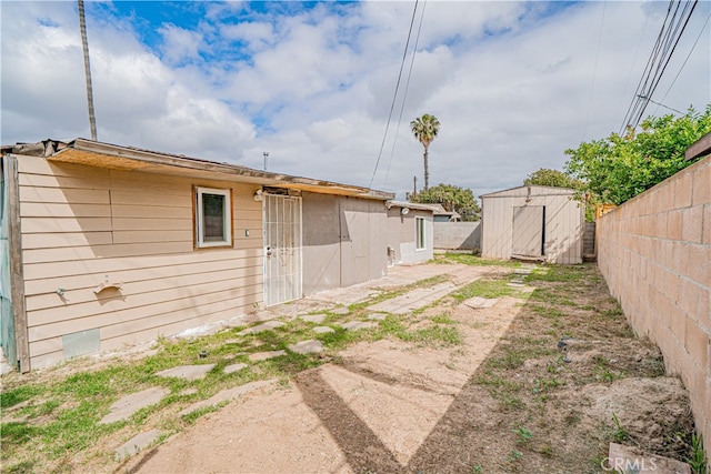 view of yard with an outdoor structure, a fenced backyard, and a storage unit