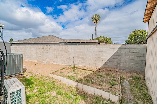view of yard featuring central air condition unit and a fenced backyard