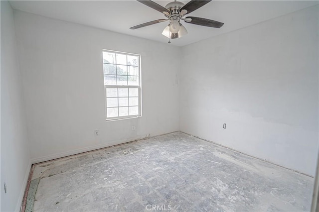 unfurnished room featuring ceiling fan and baseboards