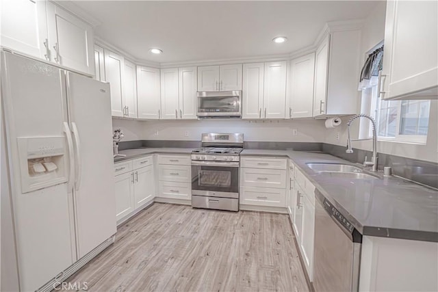 kitchen with stainless steel appliances, recessed lighting, white cabinetry, and a sink