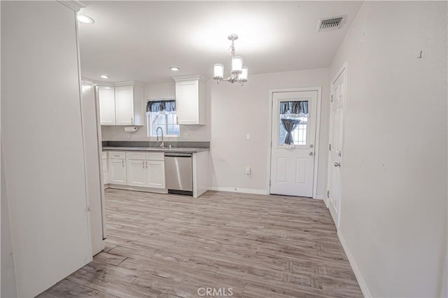 kitchen featuring white cabinets, an inviting chandelier, a sink, light wood-style floors, and stainless steel dishwasher