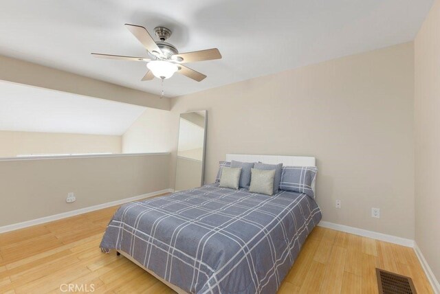 bedroom with baseboards, ceiling fan, wood finished floors, and visible vents