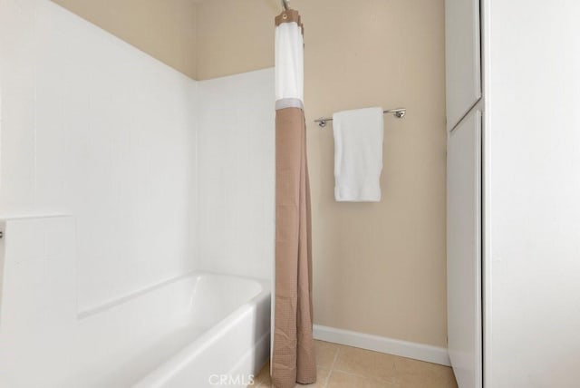 bathroom with baseboards, tile patterned floors, and shower / tub combo