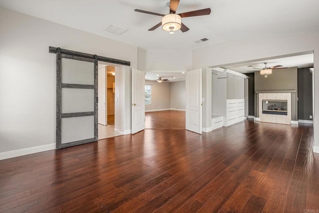 31746 Palomar Rd, Menifee, CA 92584 - unfurnished living room with a ceiling fan, a barn door, wood finished floors, and a tile fireplace