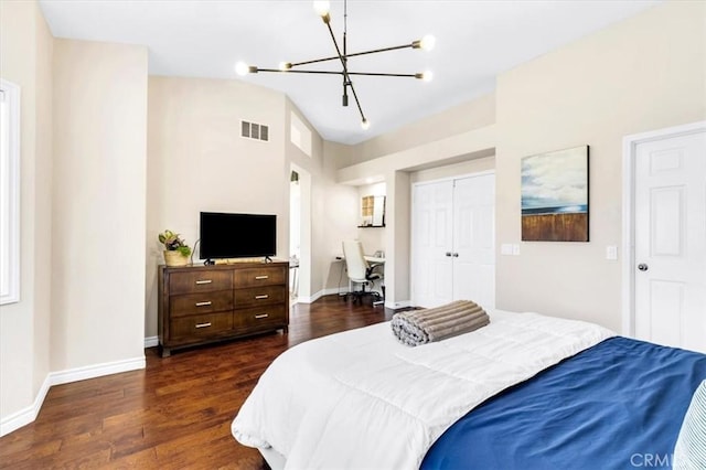 bedroom with dark wood-style floors, visible vents, a notable chandelier, and a closet