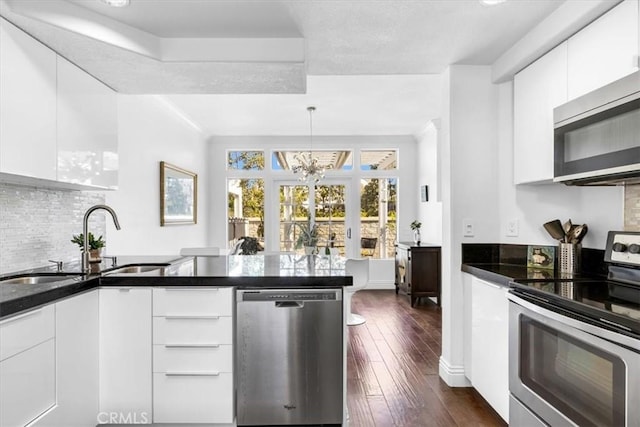 kitchen featuring white cabinets, stainless steel appliances, modern cabinets, and a sink