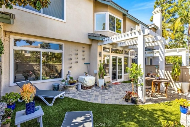back of property with a patio, stucco siding, a lawn, and a pergola