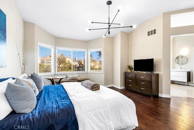 bedroom with a notable chandelier, hardwood / wood-style flooring, visible vents, baseboards, and lofted ceiling