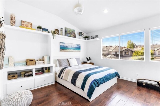 bedroom featuring hardwood / wood-style flooring, lofted ceiling, and baseboards