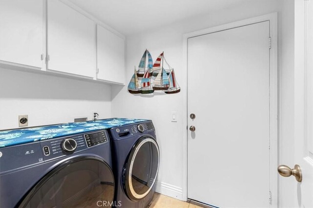 laundry room featuring washer and dryer, cabinet space, and baseboards