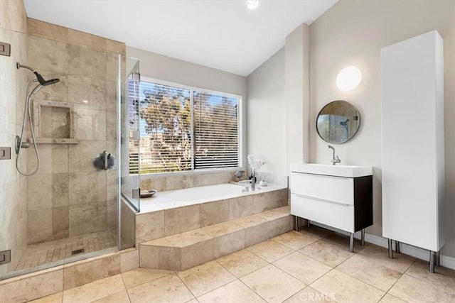 bathroom featuring tile patterned floors, vanity, a bath, and a stall shower