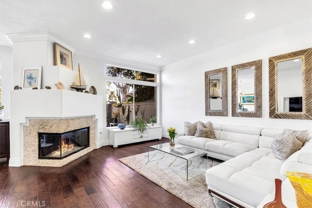 living room with hardwood / wood-style flooring, a glass covered fireplace, crown molding, and recessed lighting
