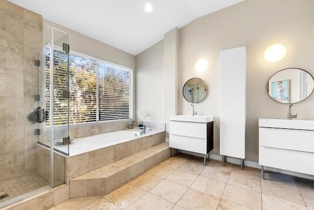 full bath with two vanities, a shower stall, vaulted ceiling, a sink, and a garden tub