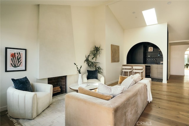 6144 W 76th St, Los Angeles, CA 90045 - living area featuring high vaulted ceiling, wood finished floors, a tiled fireplace, baseboards, and wine cooler
