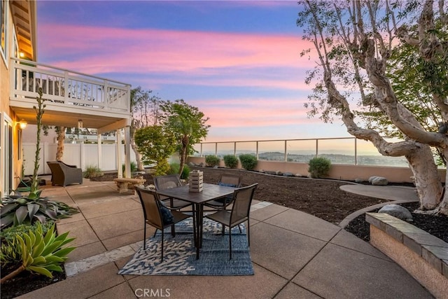 43 La Sordina, Rancho Santa Margarita, CA 92688 - patio terrace at dusk featuring outdoor dining space, a fenced backyard, and a balcony