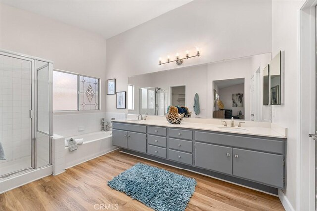 43 La Sordina, Rancho Santa Margarita, CA 92688 - bathroom featuring a garden tub, a stall shower, double vanity, and wood finished floors