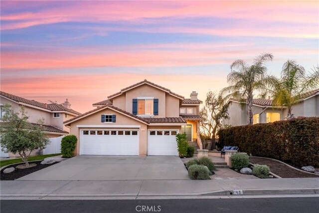 43 La Sordina, Rancho Santa Margarita, CA 92688 - view of front of house featuring stucco siding, driveway, fence, a chimney, and a tiled roof