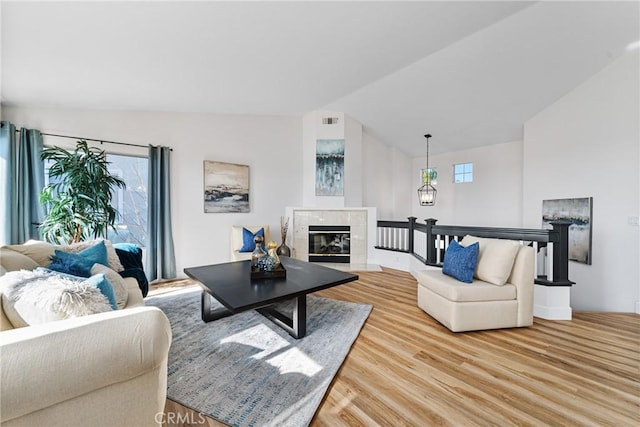 43 La Sordina, Rancho Santa Margarita, CA 92688 - living room featuring a tile fireplace, light wood-type flooring, and lofted ceiling